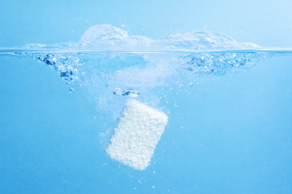 Fizzly clean tablet dissolving in water with bubbles on a blue background