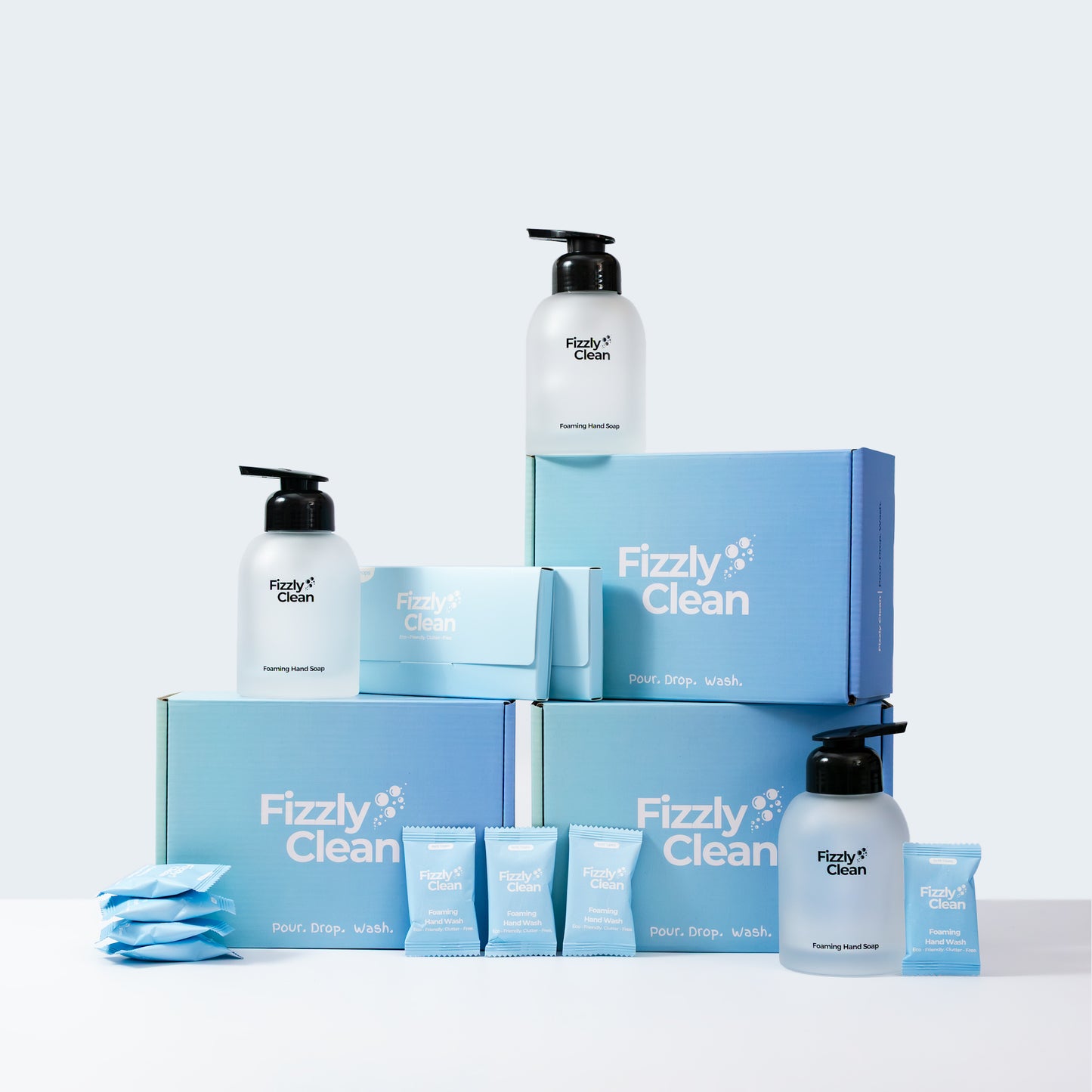 Fizzly Clean product set including bottles, starter kit boxes, and handsoap tablets on a light gray background