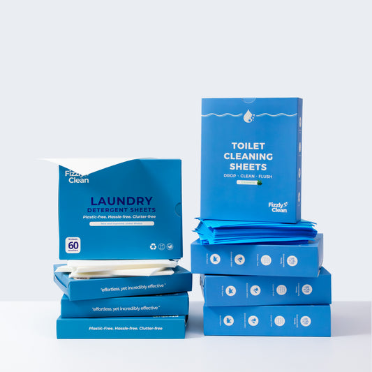 Blue boxes of Fizzly Clean laundry detergent sheets and toilet cleaning sheets on a white background
